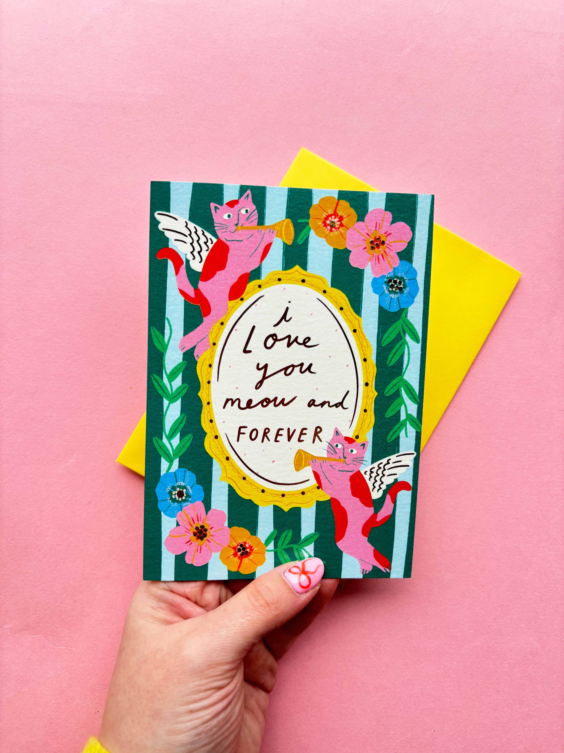 I love you meow and forever is a greeting card created by Kerrie McNeill (Kerrie Illustrates) based in Northern Ireland. This card is blue and green striped with cat cherubs and floral motifs around the edges of the hand-written caption