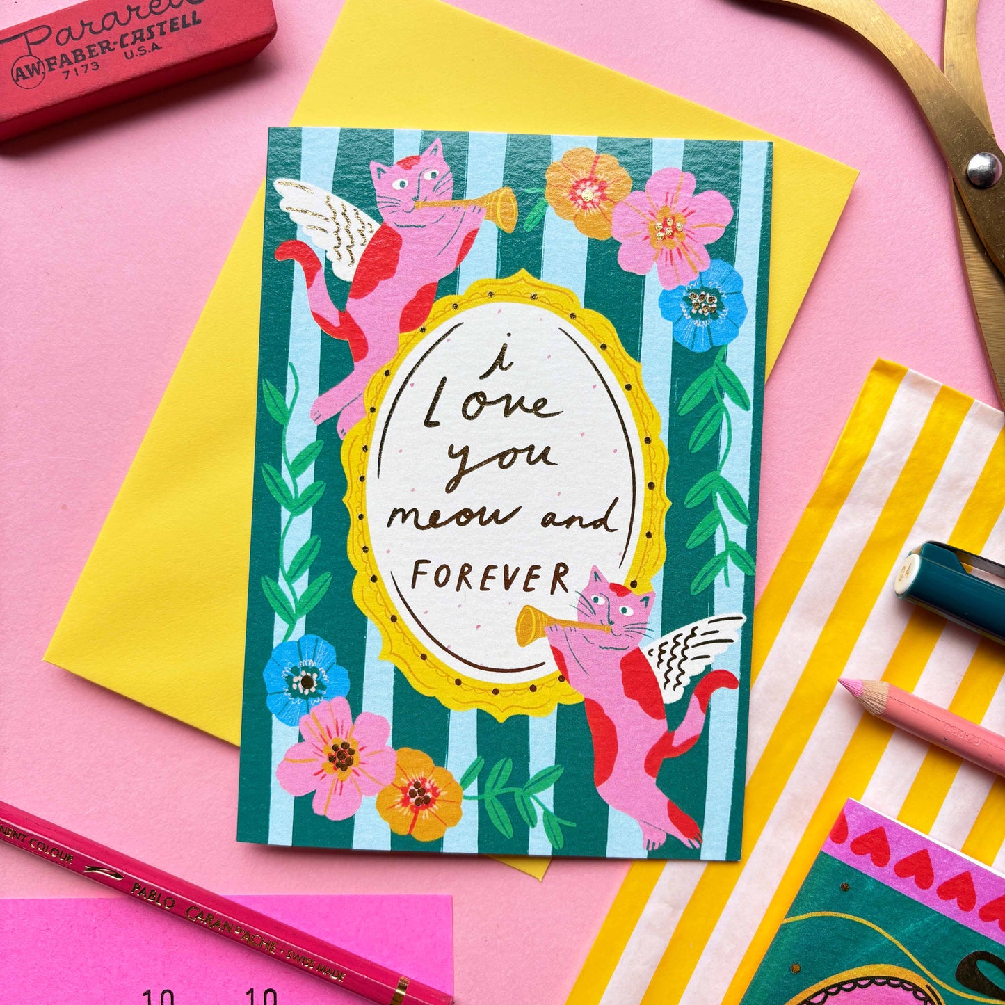 I love you meow and forever is a greeting card created by Kerrie McNeill (Kerrie Illustrates) based in Northern Ireland. This card is blue and green striped with cat cherubs and floral motifs around the edges of the hand-written caption