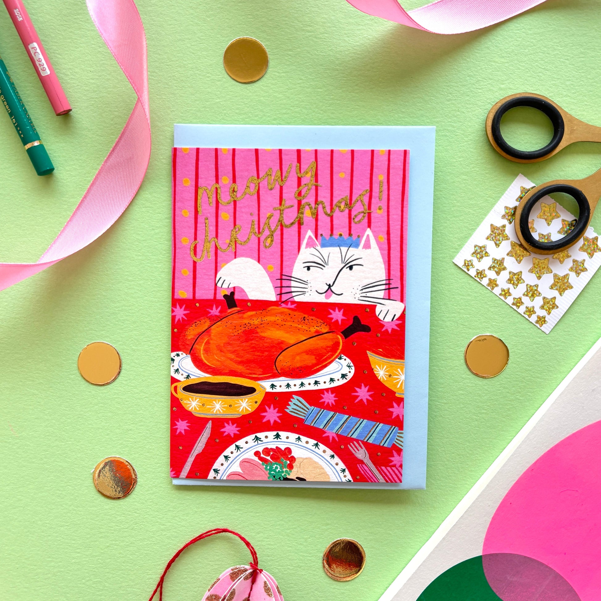 ‘Meowy Christmas’ funny cat Christmas card showing a naughty cat licking its lips at a festive dinner table with turkey and gold foil details