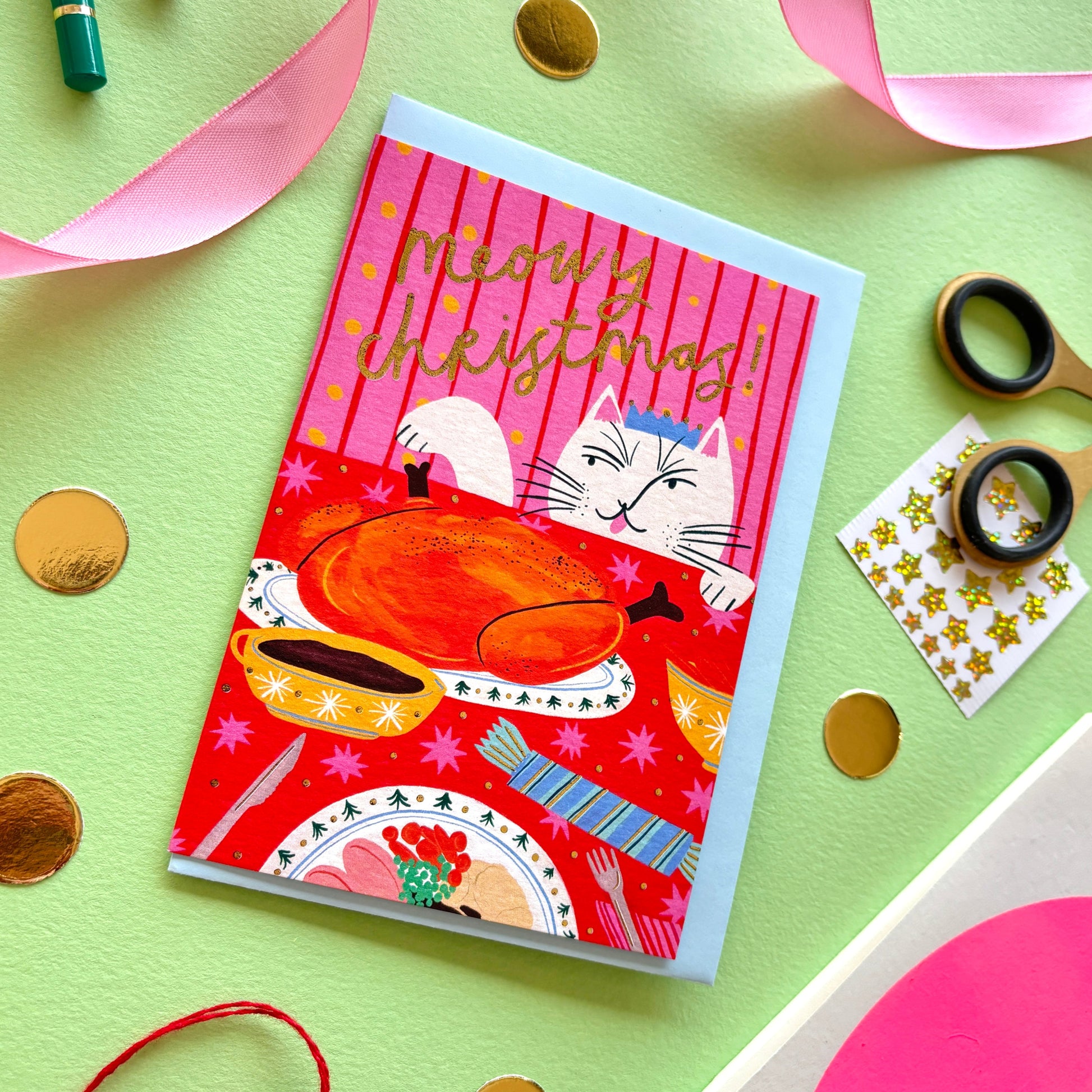 ‘Meowy Christmas’ funny cat Christmas card showing a naughty cat licking its lips at a festive dinner table with turkey and gold foil details