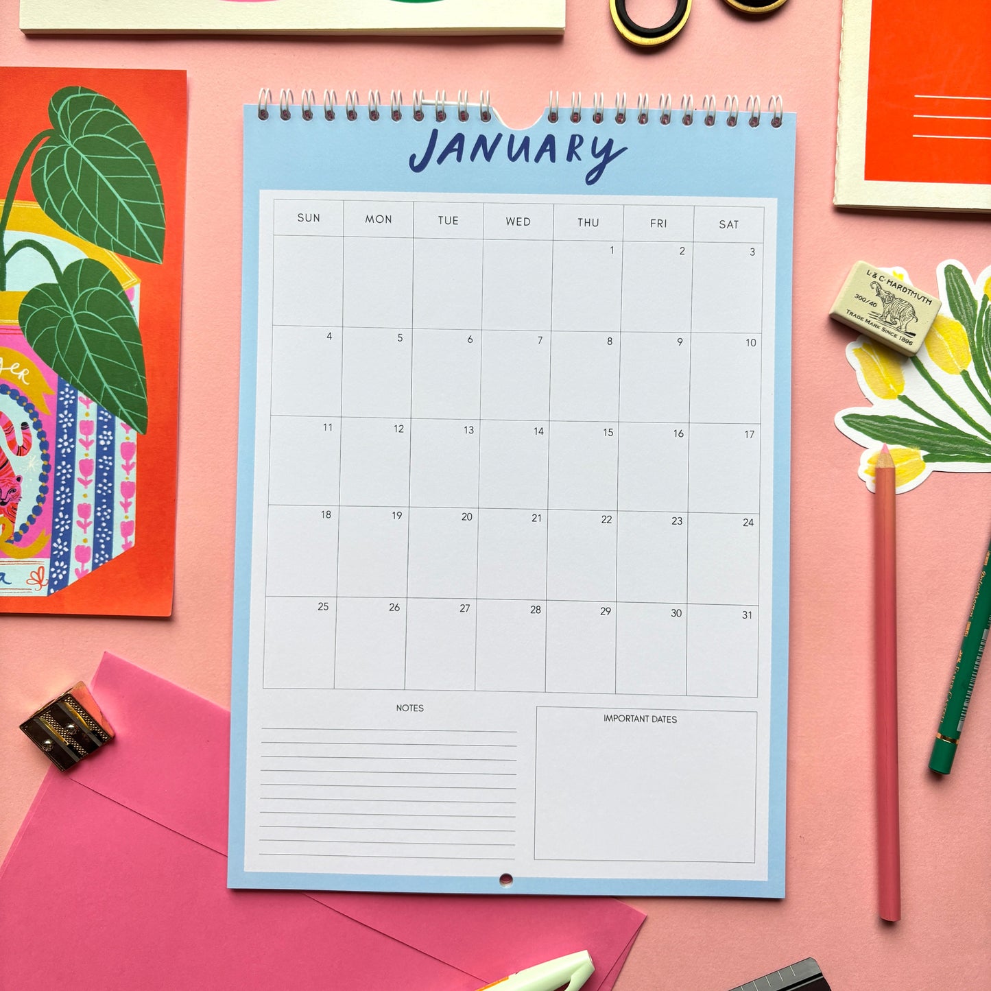 Calendar for January on a pink background with stationery items