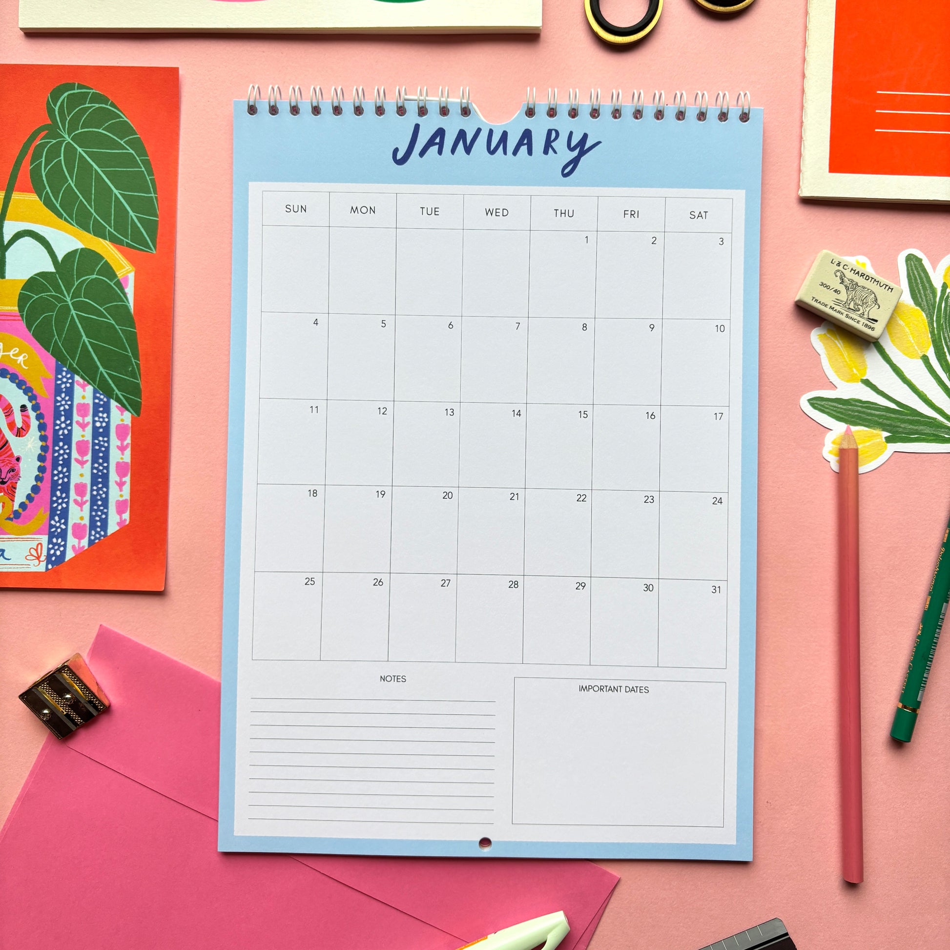 Calendar for January on a pink background with stationery items