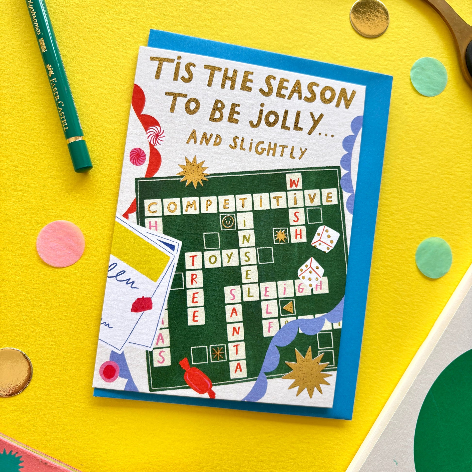 Funny Christmas card featuring Scrabble board with Christmas words, gold stars, bunting and sweets – perfect holiday card for game nights.